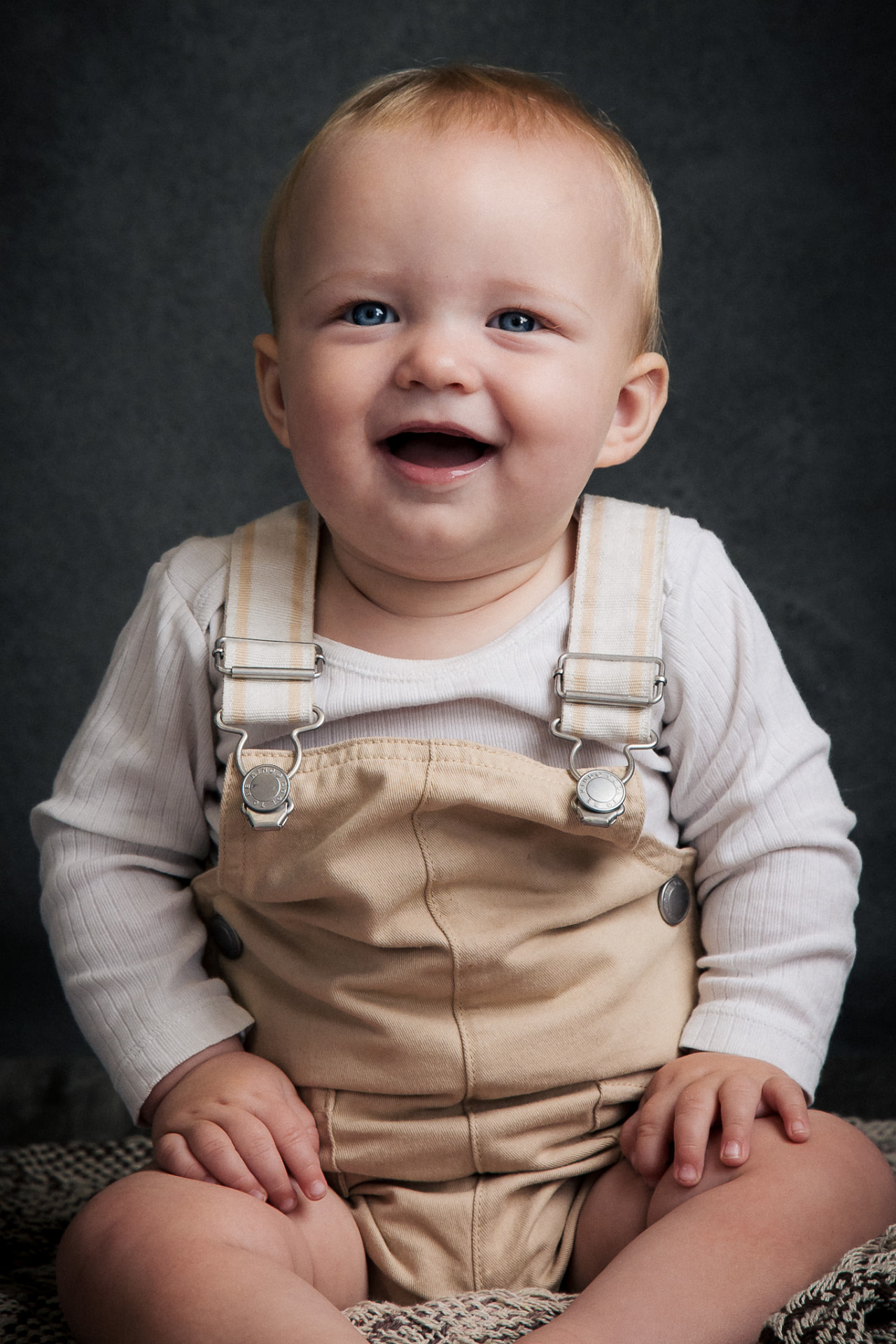 Baby i beige seler smiler i studie i Aabybro