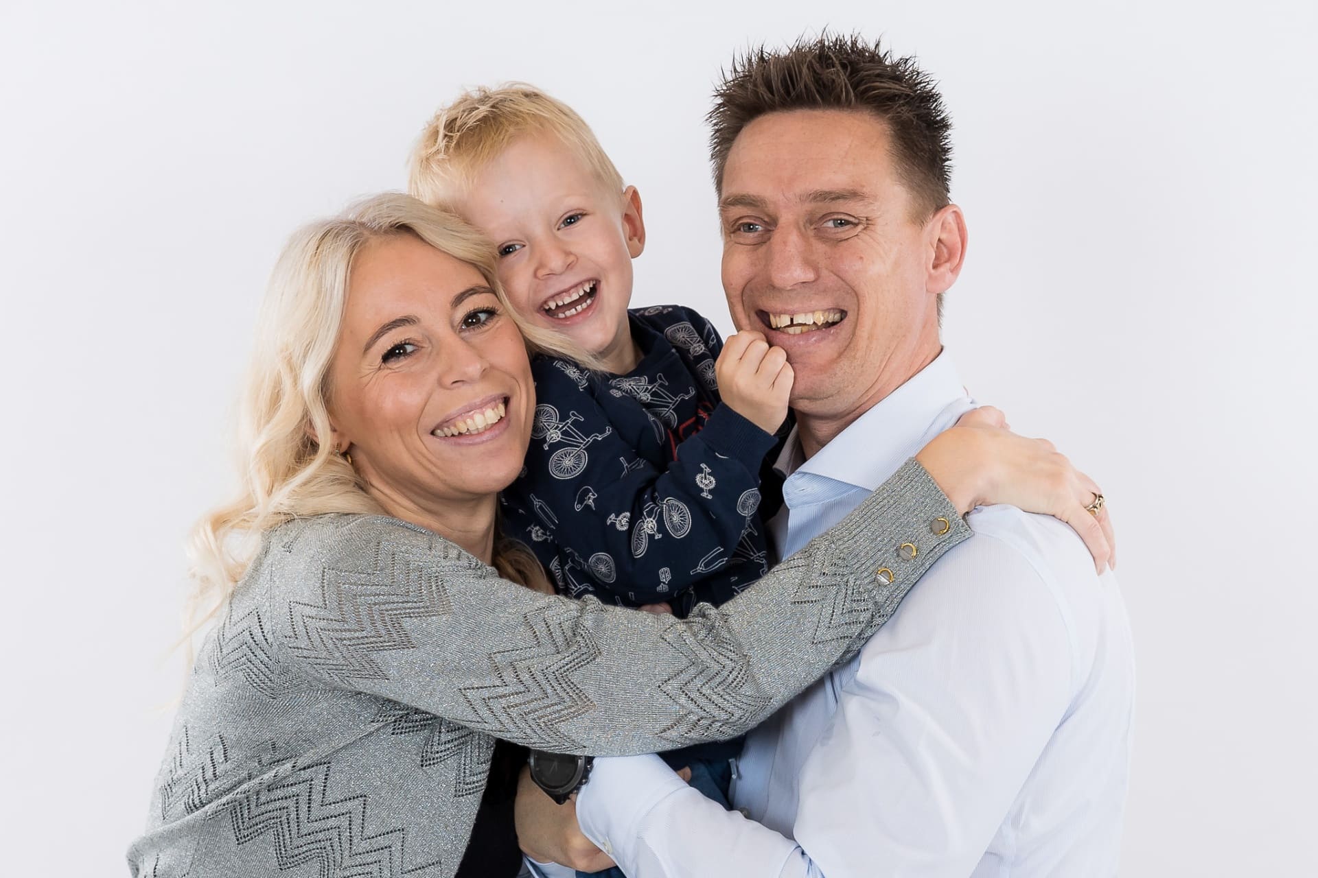 Familie griner sammen under fotografering – ægte øjeblik fanget i studie