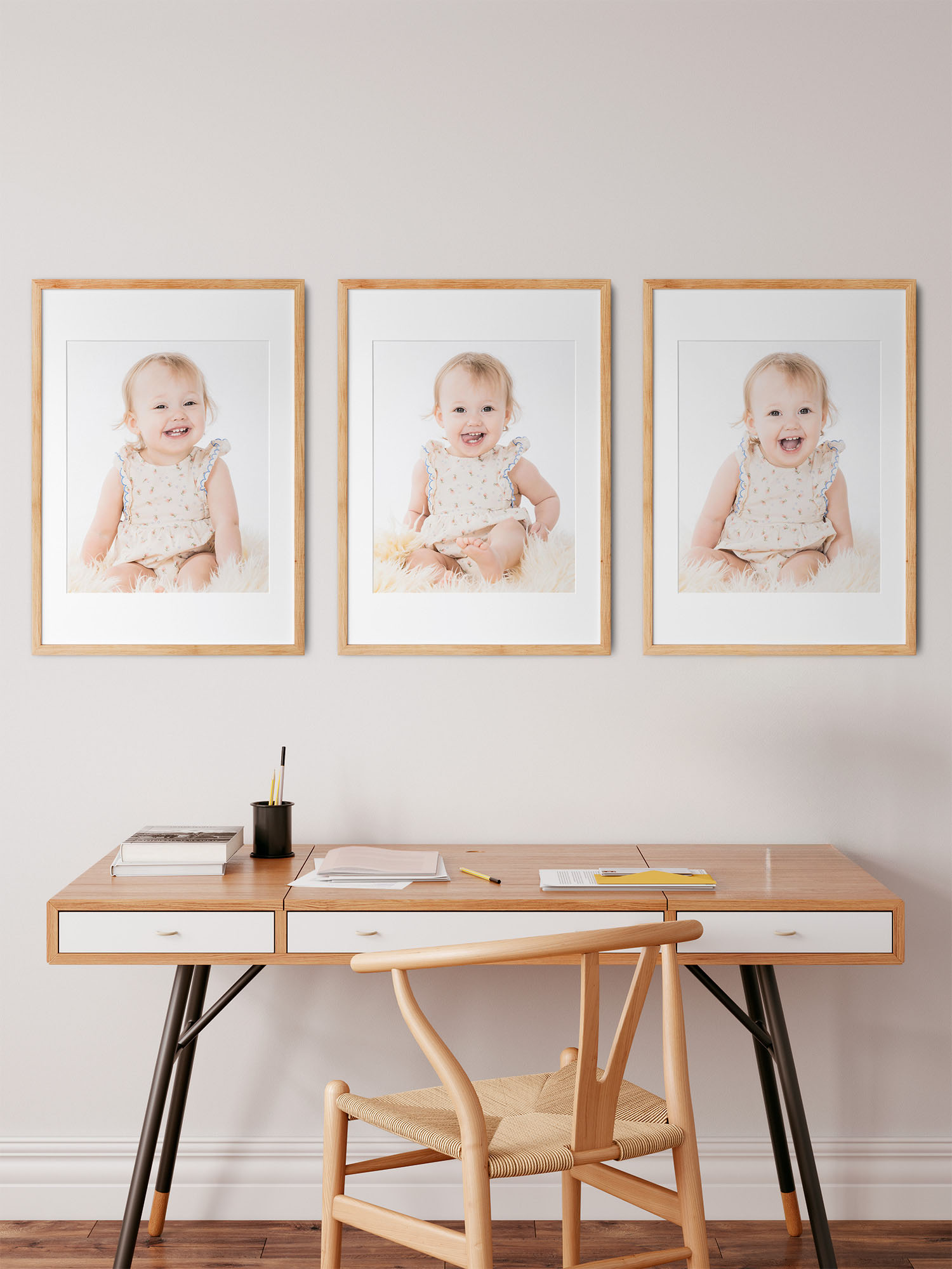 Tre babybilleder i serie på væg