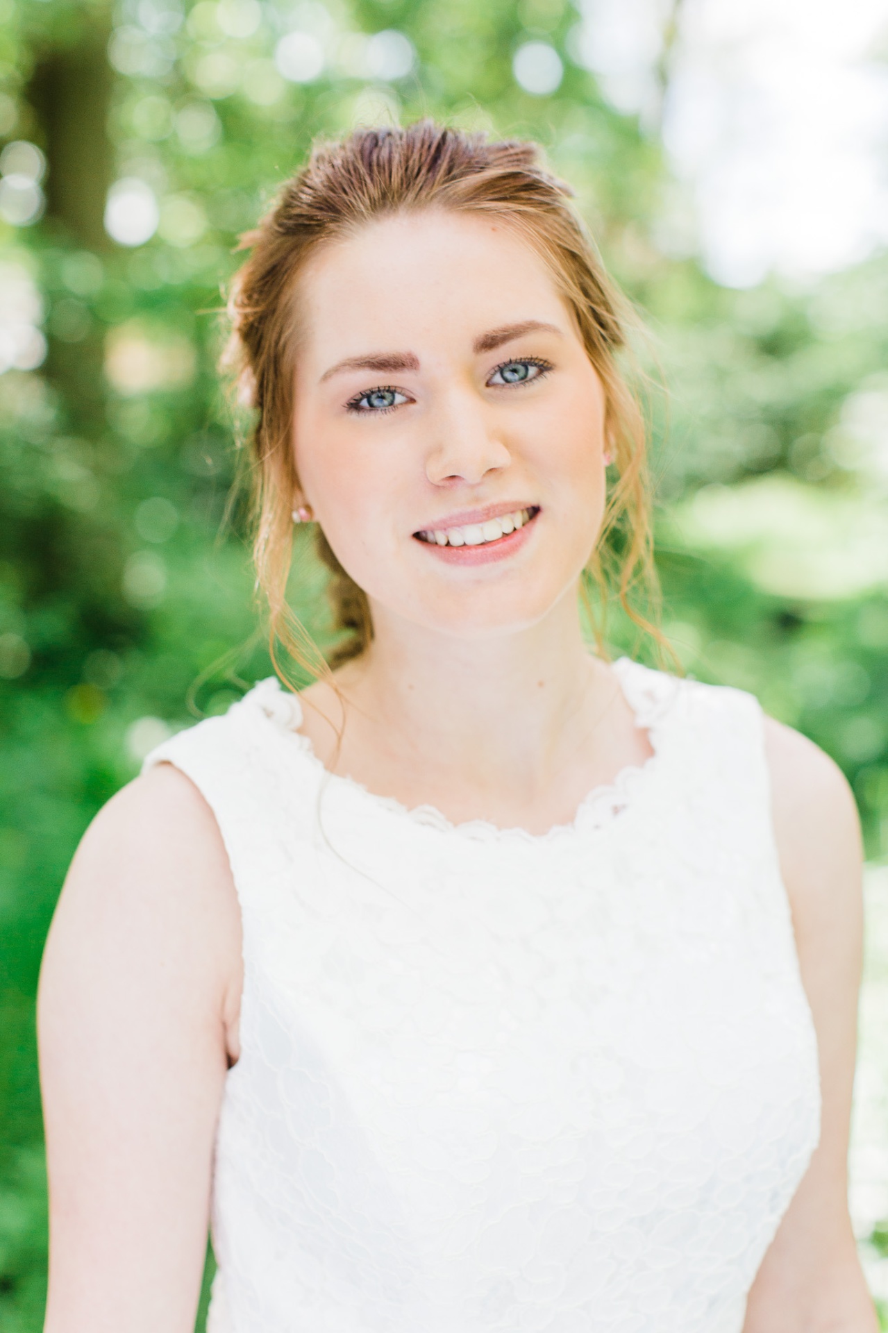 Smilende konfirmand i hvid kjole