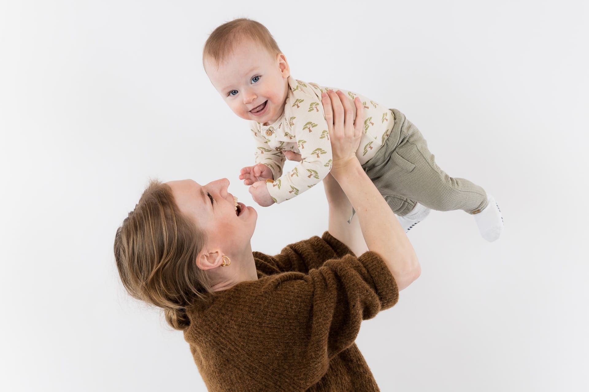 Mor leger med baby i lyst fotostudie