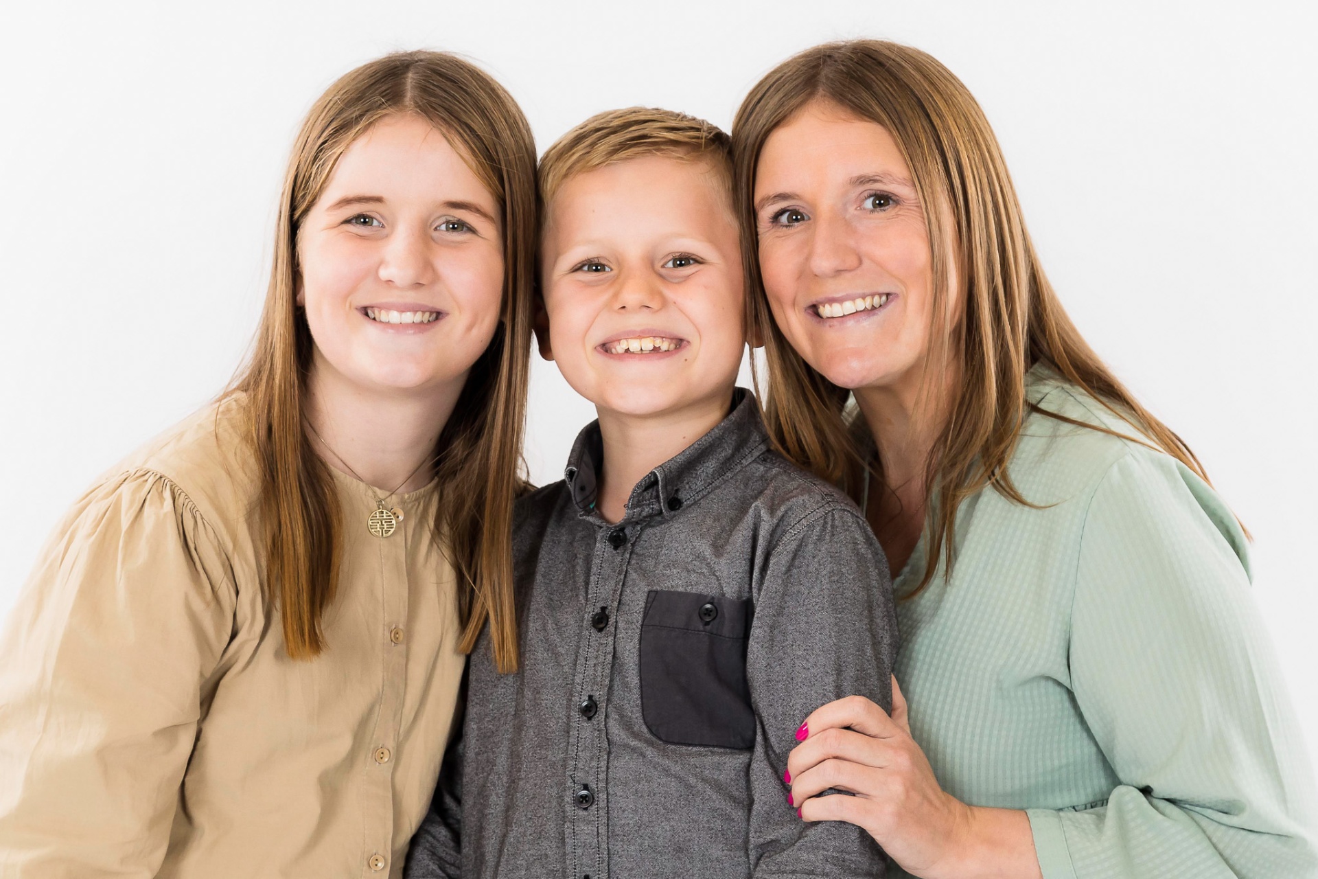 Mor med børn i pastelfarvet tøj – afslappet familieportræt