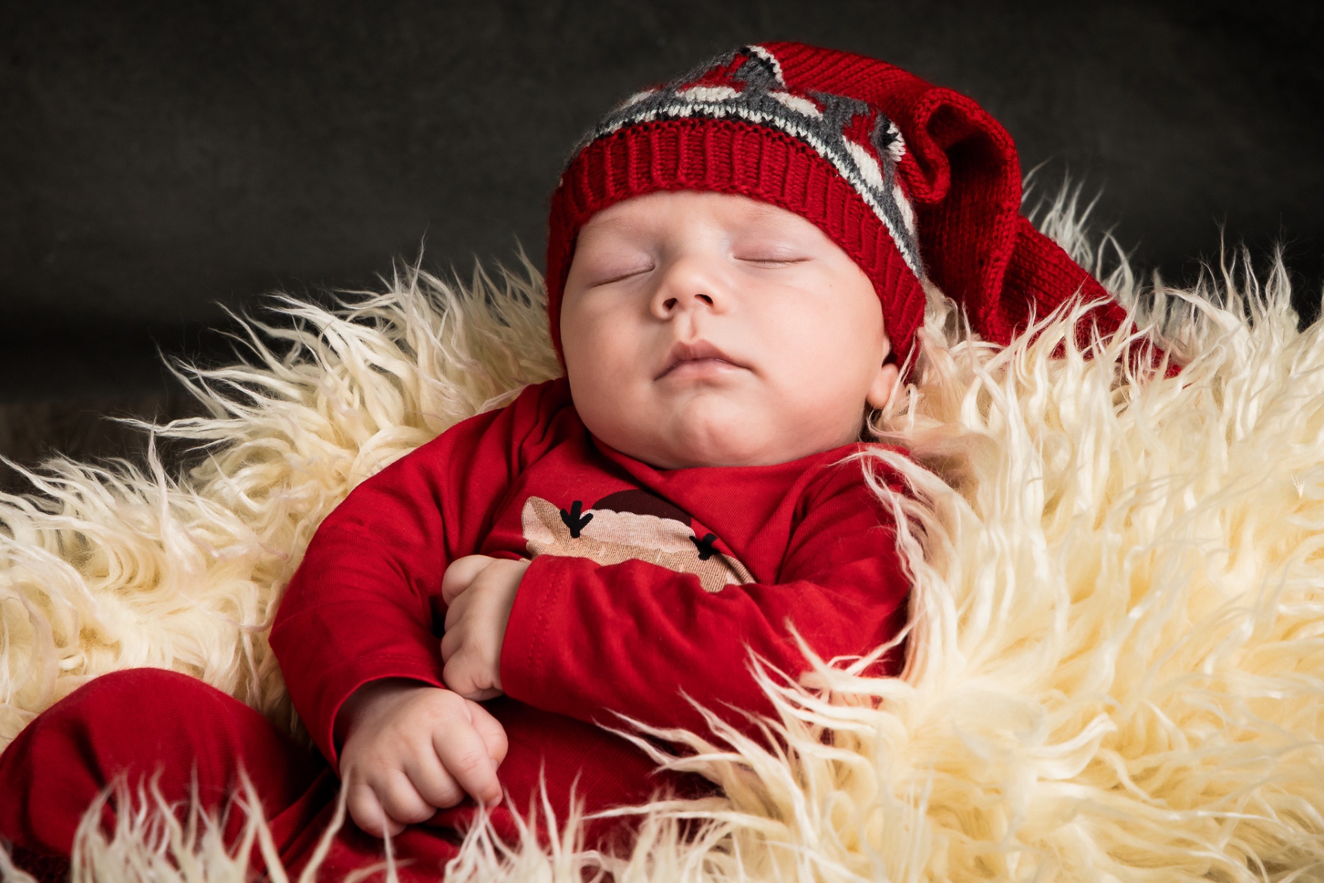 Sovende nyfødt baby i rødt tøj – nyfødt fotografering Nordjylland