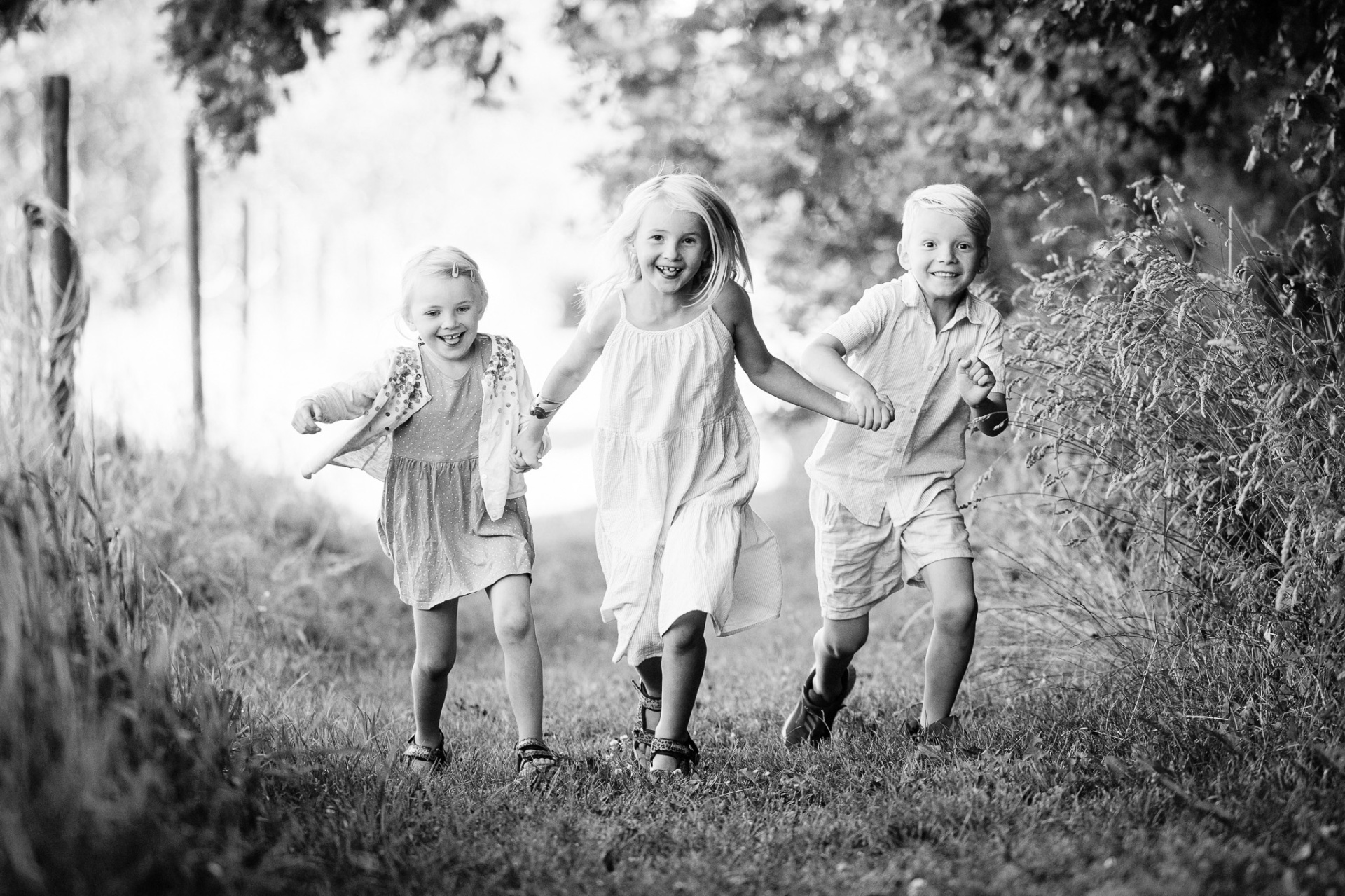 Tre børn løber på markvej